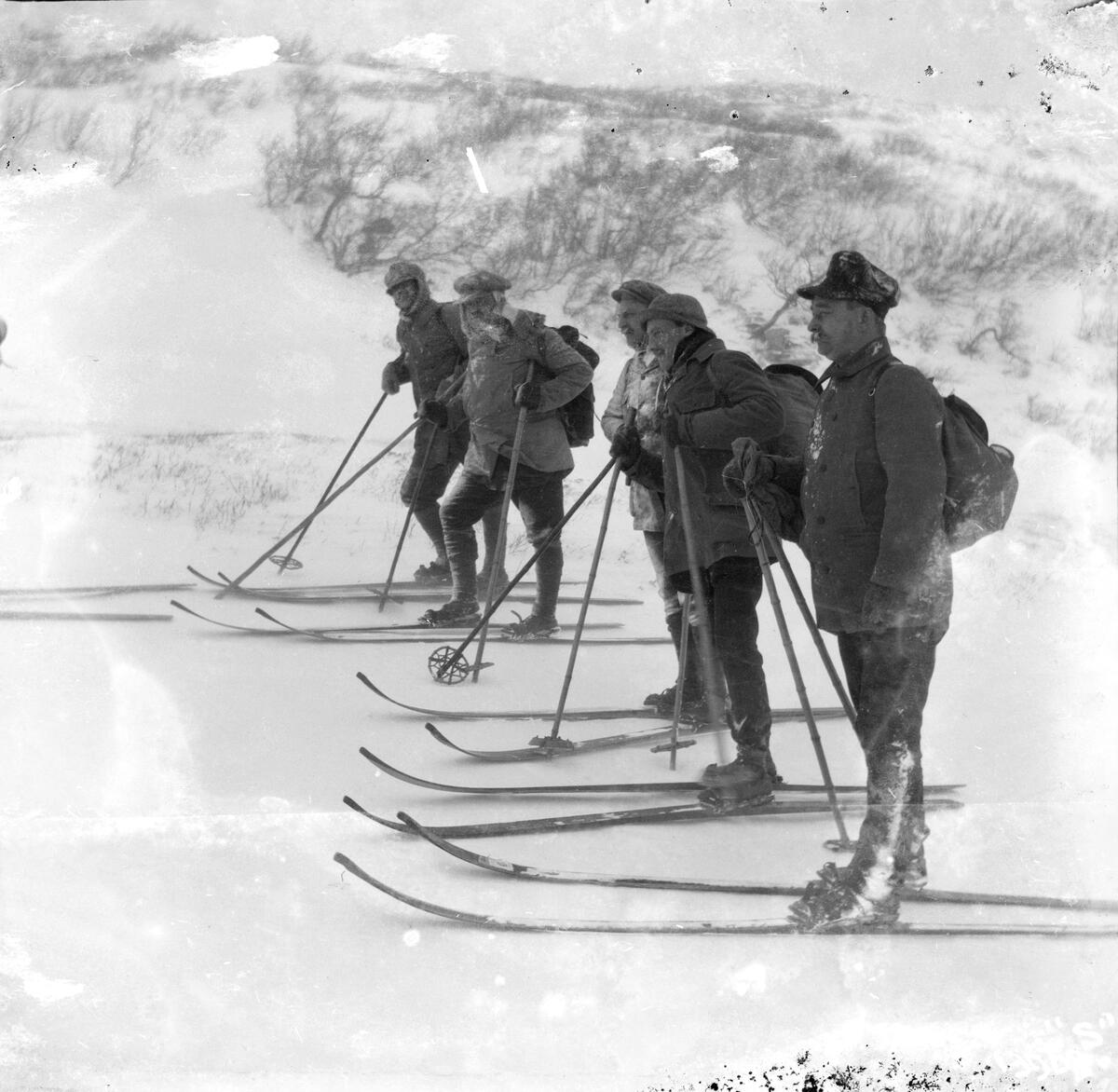 Fem menn på ski.
