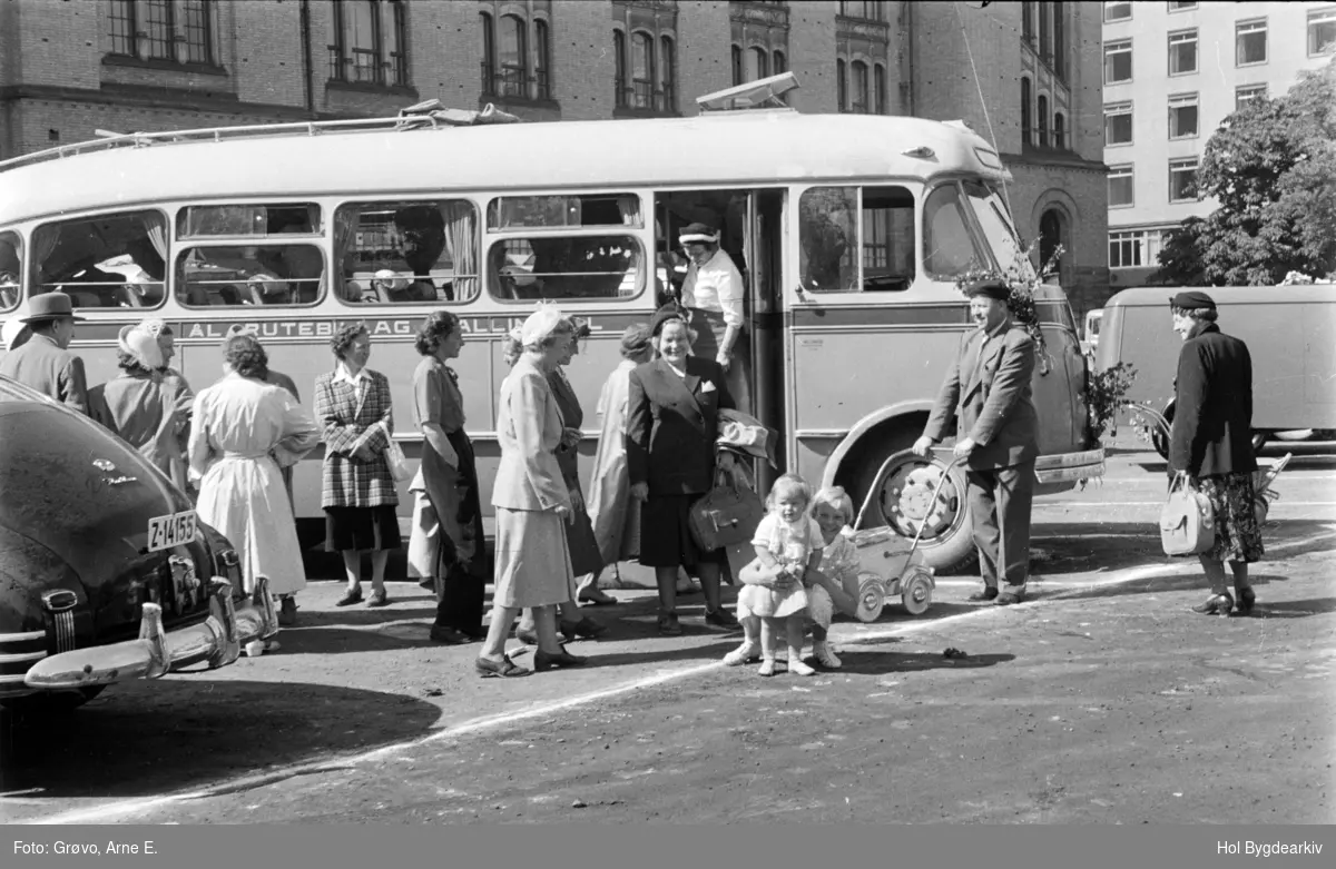 Tullinløkka i Oslo med Historisk Museum i bakgrunnen. Bilen i venstre framkant har fastbackkarosseri fra General Motors-konsernet, årsmodell 1946-48: gruppeU, reisefølge, buss, Ål Rutebillag, kvinner,