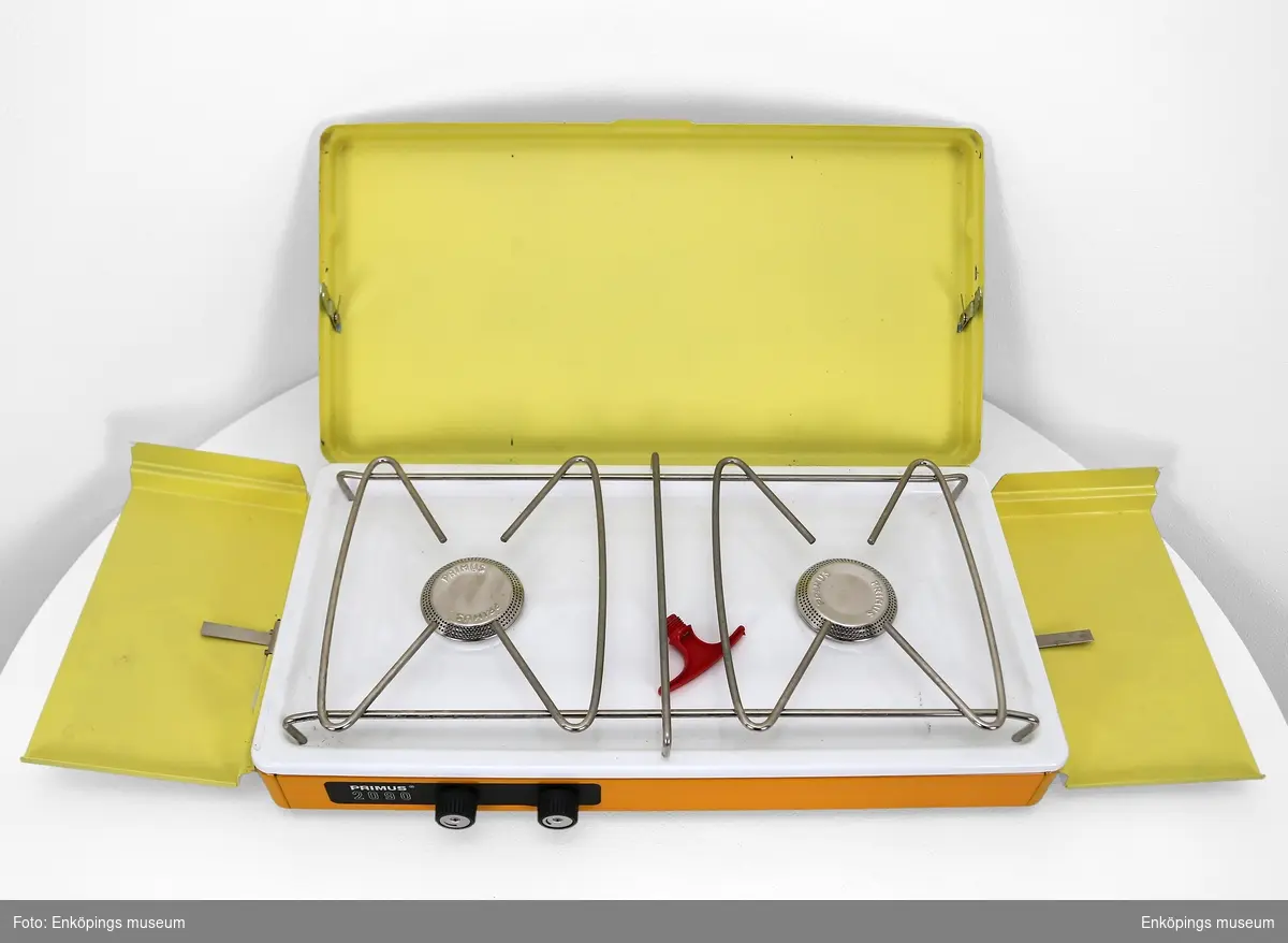 Portabelt kök i gul och orange färg, med manual.