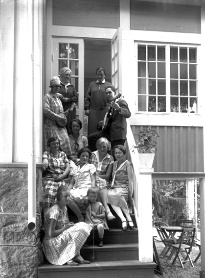 Tio personer står och sitter på trappa.
Edsgatans Pensionat.