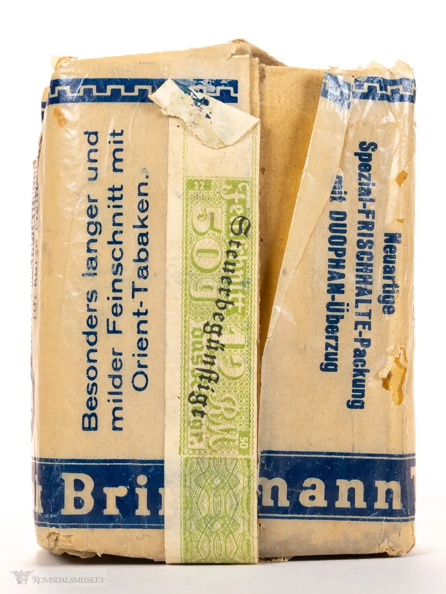 Rektangulær eske med pipetobakk. «Krigstobakk» av typen Translanta Spezial, Brinkmann Tabak. Pakken er uåpnet og inneholder 50 gram pipetobakk, beregnet for kort pipe («für kurze Pfeife»).
