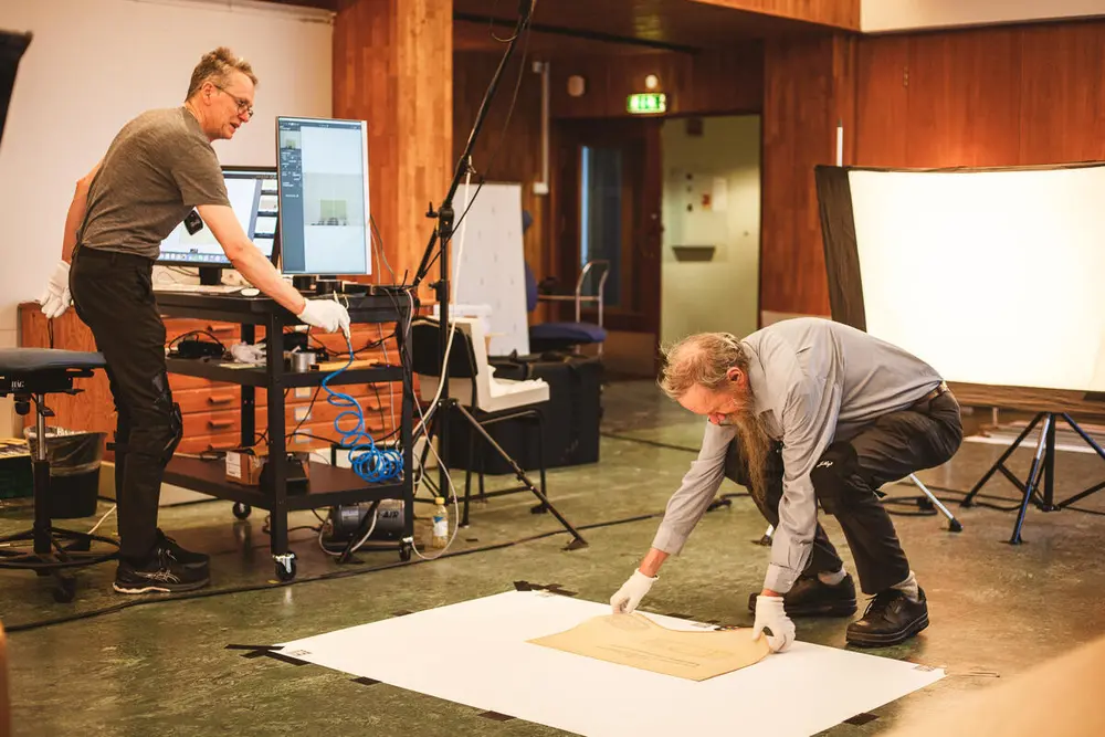 Fotografering av båttegninger, fotograf og arkivar som jobber.