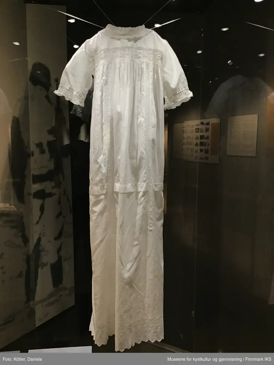 Dåpskjole sydd av silkestoff og dekorert med en kniplet prydestripe som viser hakekors.