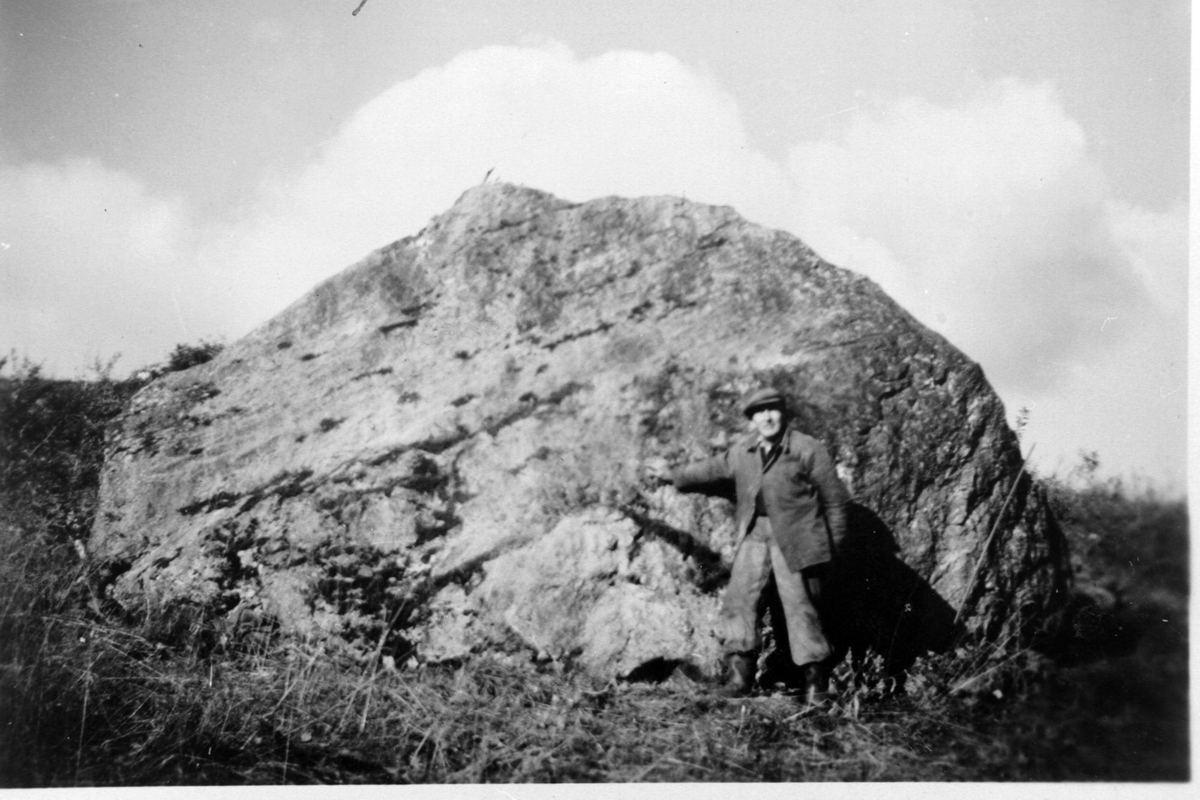 Arthur Tennvassås står ved en stor stein som blir kalt for Bjørnsteinen.