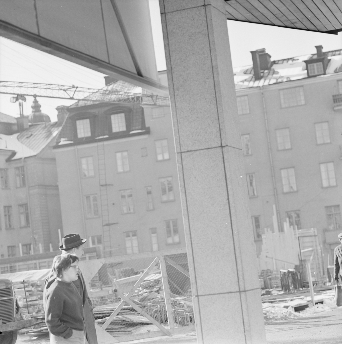 Man och kvinna promenerar förbi en byggarbetsplats, Uppsala