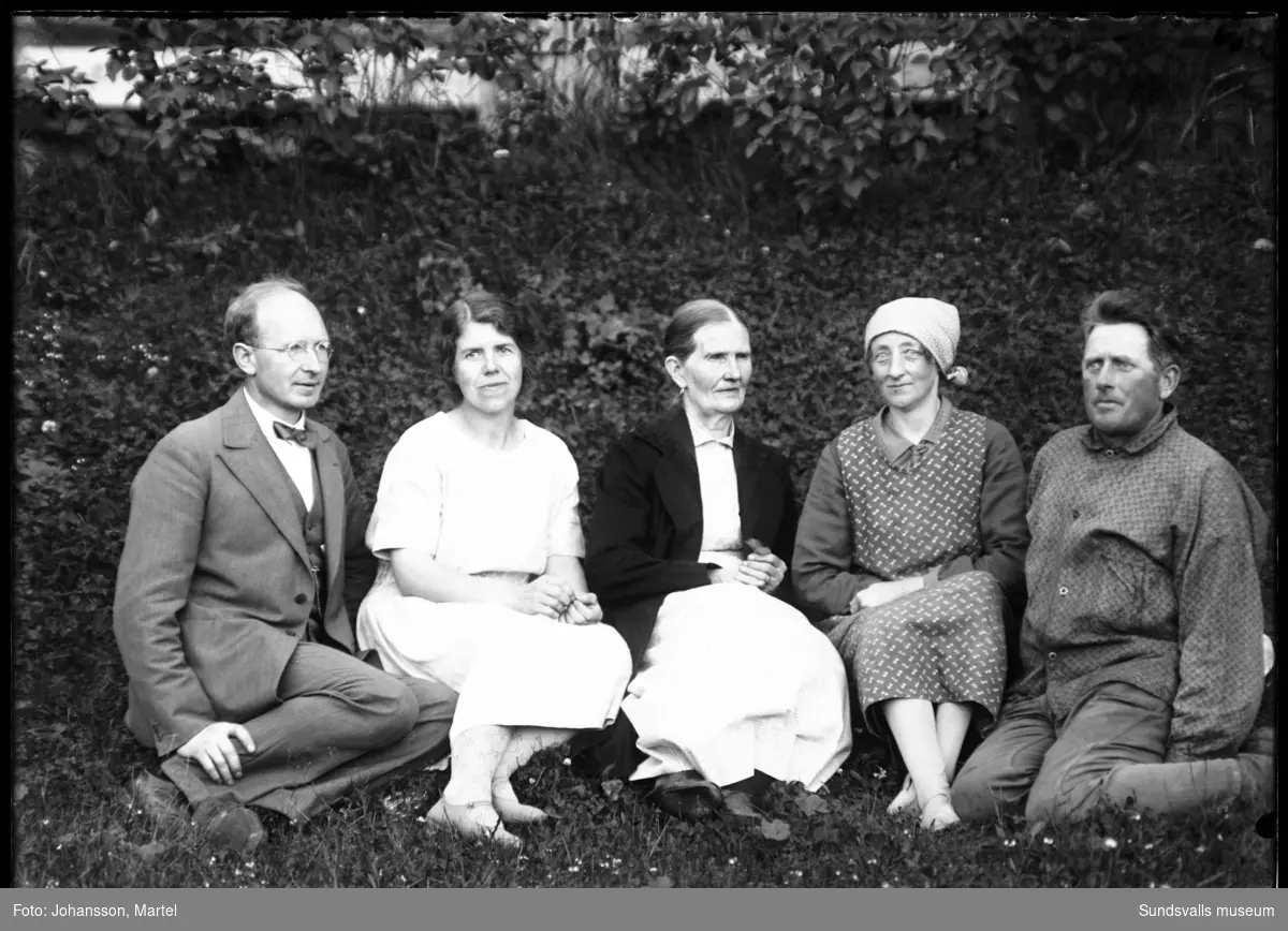 Gruppbild i gräset med från vänster: syskonen Martel och Johanna "Hanna" Johansson, deras mor Andrietta Persson samt en kvinna och en man som är oidentifierade.