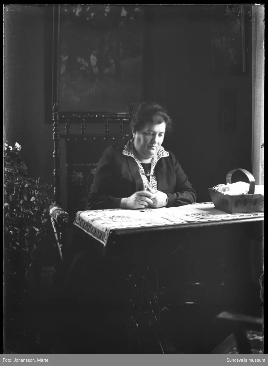 Porträtt av en kvinna som sitter och lägger patiens.