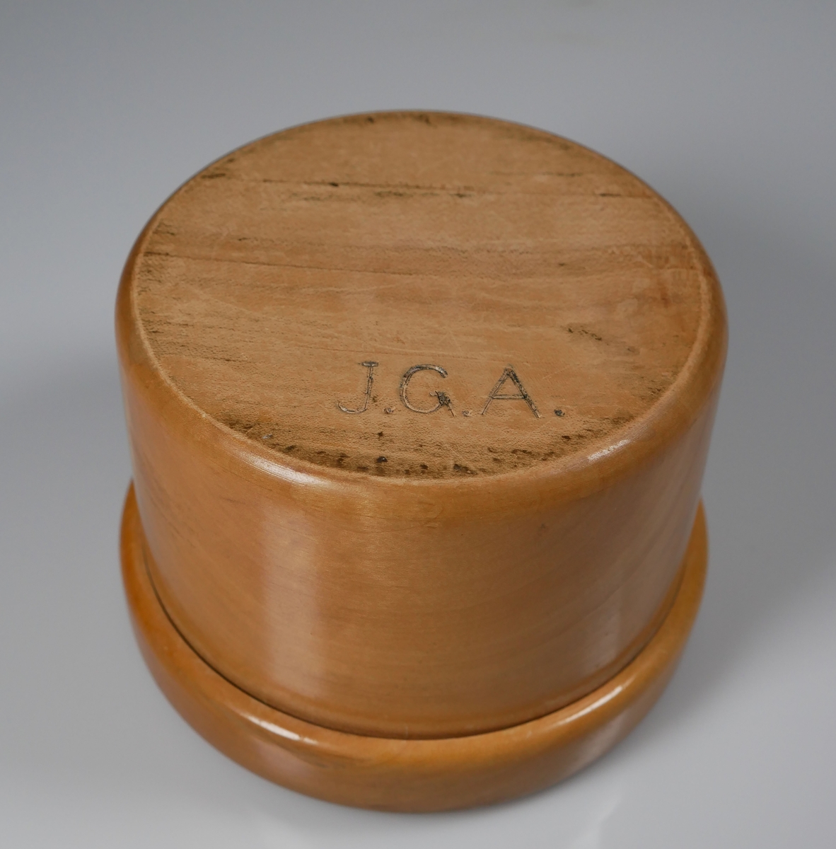 Träask med lock. Locket något sprucket.  Undertill märkt J.G.A. = J.G. Axelssons snickeriverkstad som var verksamt mellan 1894-1966 i Alingsås.