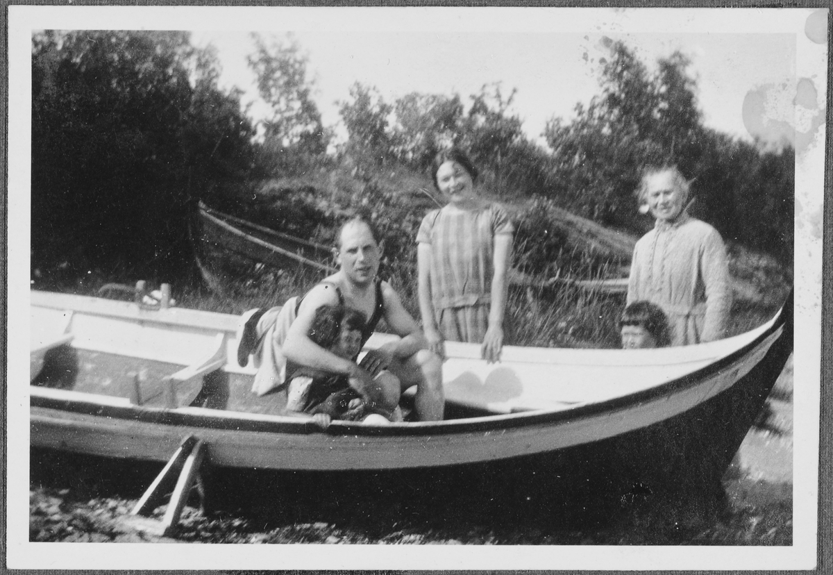 Edith Bekker. John Jacobsen, Esther Bekker, Adolf Bekker og Sara jacobsen utendørs i en båt på land.