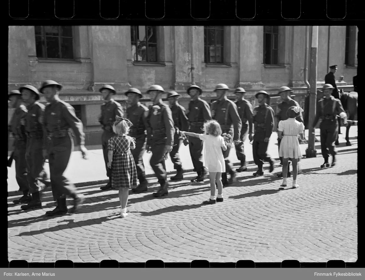 Britiske soldater marsjerer i parade i Oslo på de alliertes dag den 30. juni 1945 (The Allied Forces day)

Flere barn springer for å rekke soldatene blomster