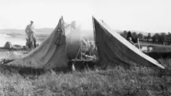 To telt, lagd av presenninger, oppsatt som gapaskjul med kor