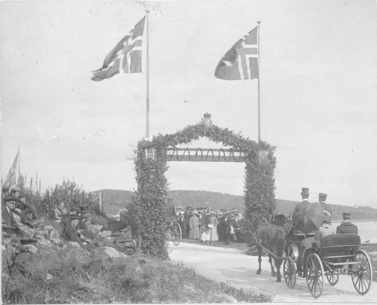 En av portalene laget i forbindelse med besøk fra kong Haakon VII og dronning Maud på Melbu. Kongen og dronningen fraktes i hestevogn opp til Melbo Hovedgård