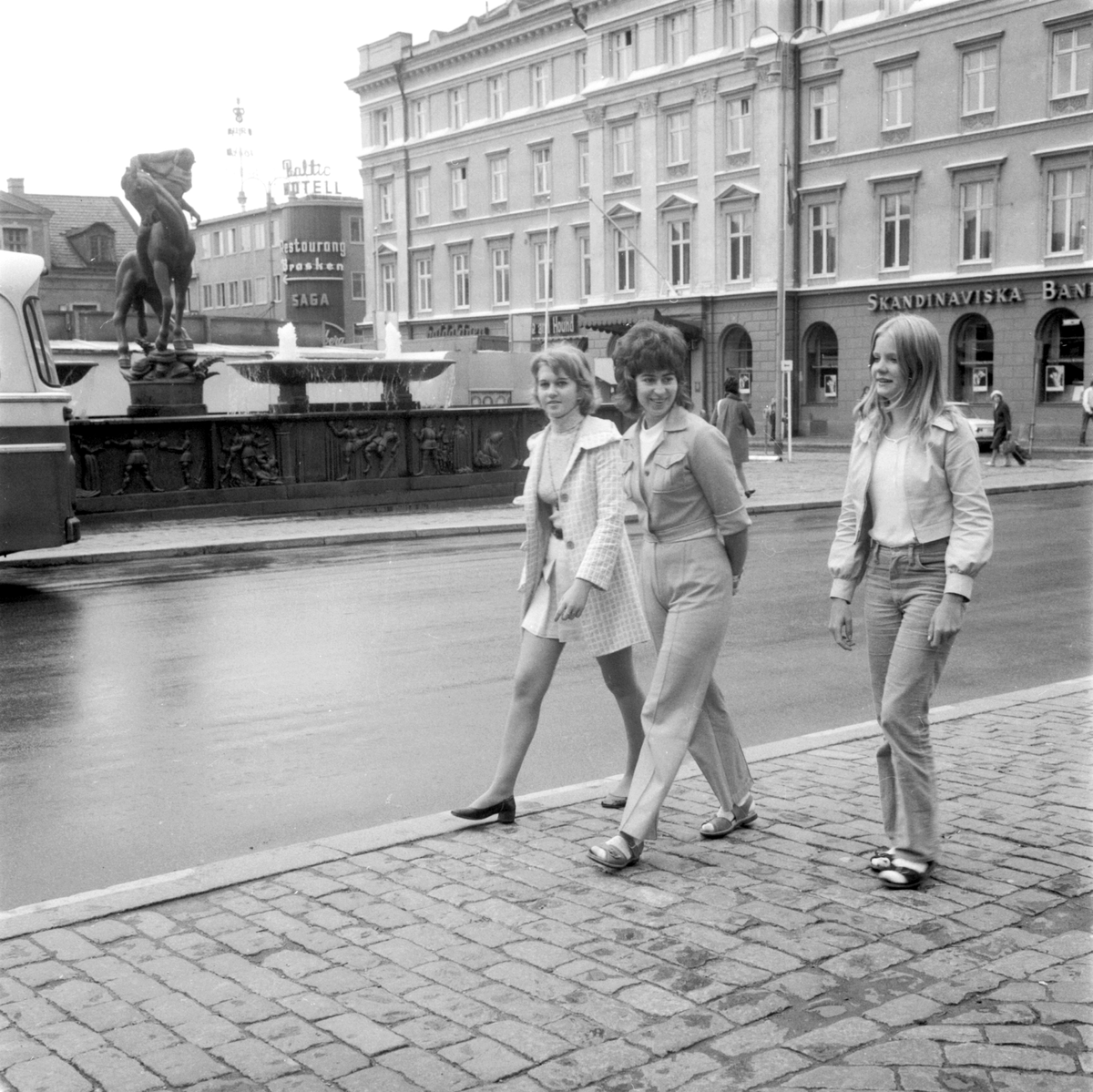 Vy över Stora torget i Linköping 1971. Unga kvinnorna passerar i tidens mode. I övrigt är miljön i det närmaste oförändrad.
