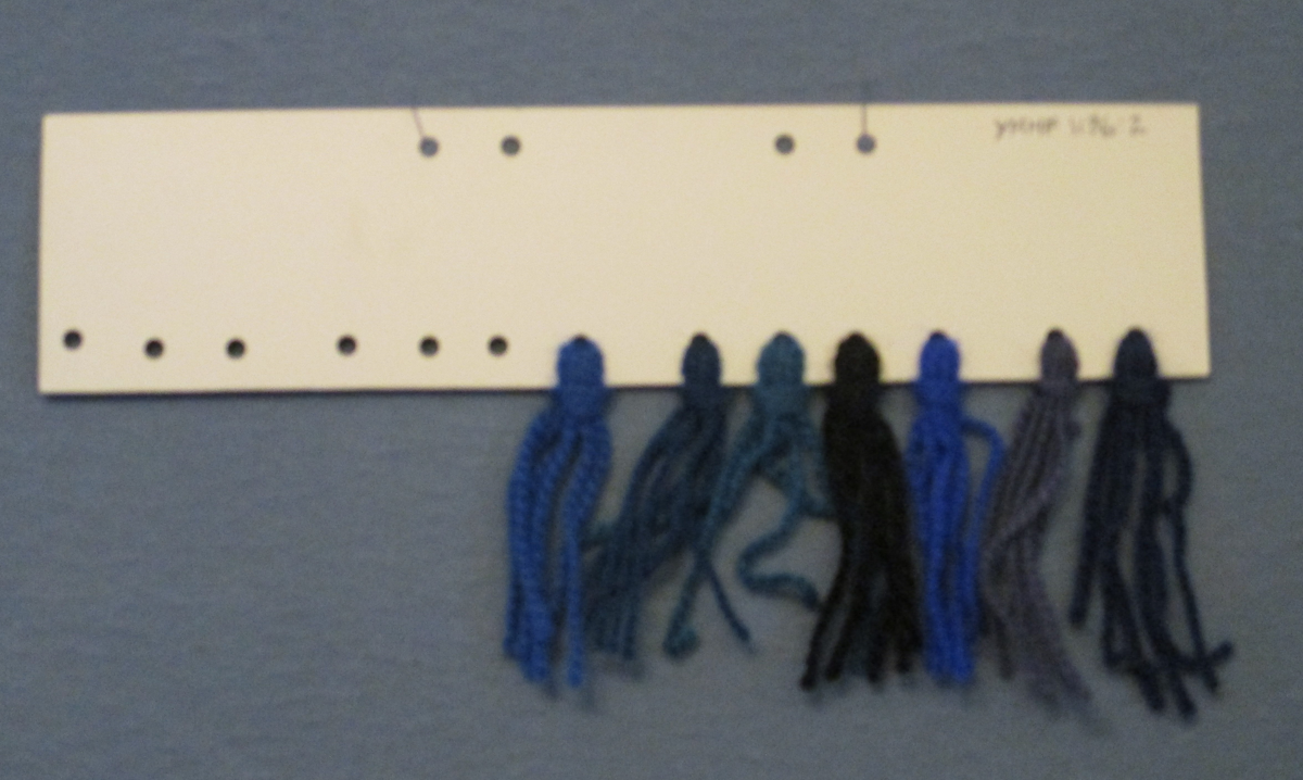 Färgskiss på rutpapper och garnprov till ryamatta  i blåa nyanser. Storlek107x170 cm