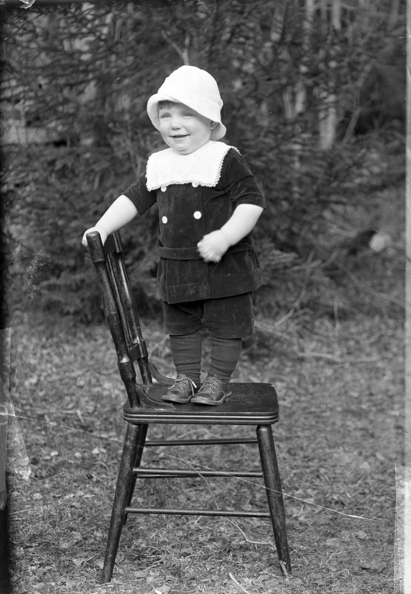 Fotosamling etter Øystein O. Jonsjords (1895-1968), Tinn. 

Bilde viser portrett av Torgny Aarlie født 20.09.1918 stående på en pinnestol. Bildet tatt i 1919