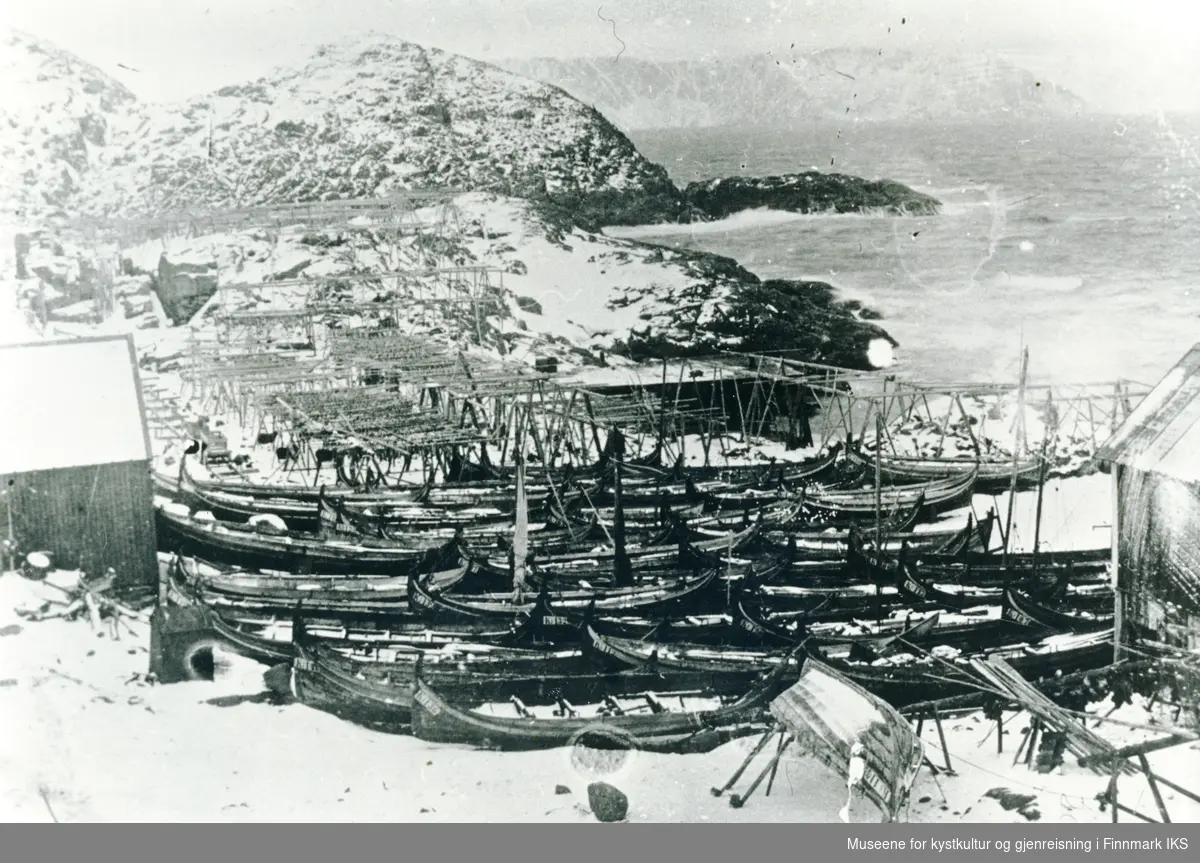 Helnes med fiskehjeller og mange Nordlandsbåter trukket på land. Omkring 1900.