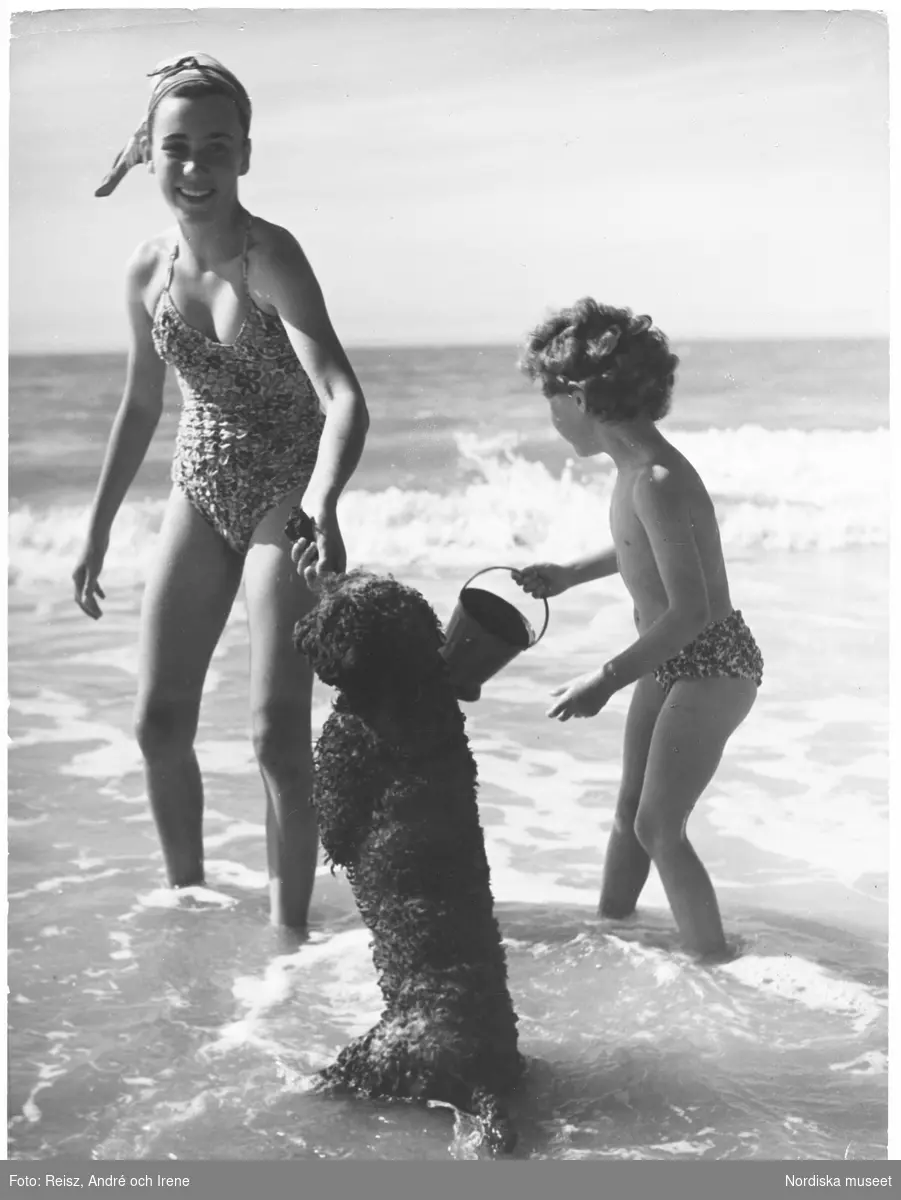 En flicka och en pojke badar med sin hund.