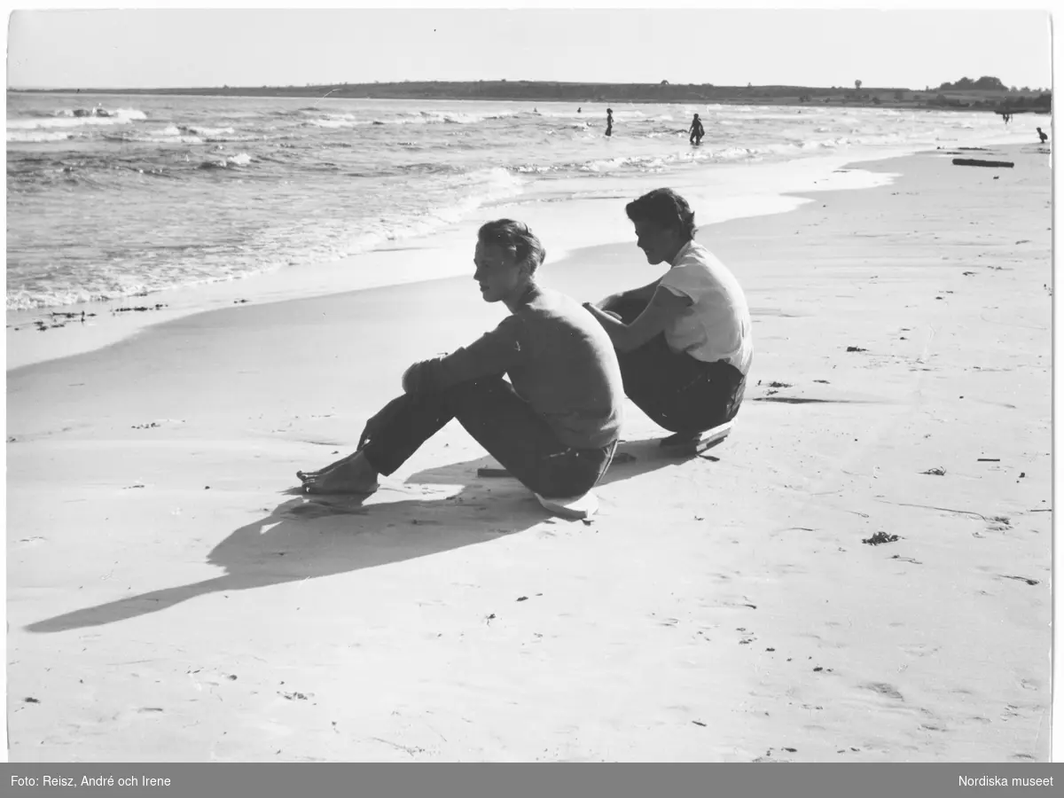 Ett par sitter på Sudersand strand vid havet på Fårö.