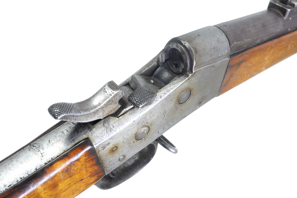 Armégevär med mekanism av typ Remington Rolling Block, med centralantändning. Kolven är av trä har en smal kolvhals och bakplåt av stål. Framstocken har tre band och är försedd med laddstocksränna och laddstock av stål. Det mellersta bandet har en bärremsbygel. Den andra bygeln är fästad i varbygelns främre del. På pipan sitter ett klaffsikte, och längts ut vid mynningen ett korn. Siktet har avståndsmarkeringar på sidorna. Ute vid mynningen finns även ett bajonettfäste på pipans högersida. Loppet är pluggat i patronläget med hjälp av en isvetsad plugg. Pipan är räfflad och har en innerdiameter på 12,7mm. 
Inskrivet i huvudkatalogen 1974.