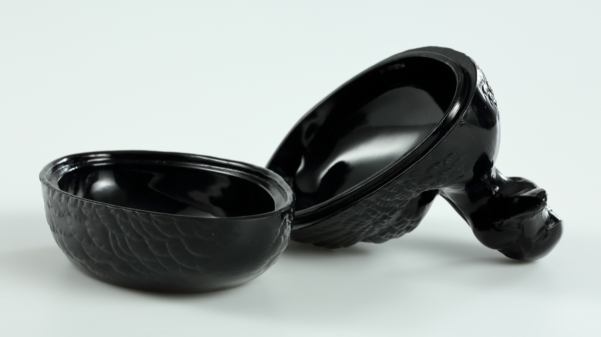 Smörask, smöranka, i svart (egentligen högkoncentrerat koboltblått) glas. Formen av en and.