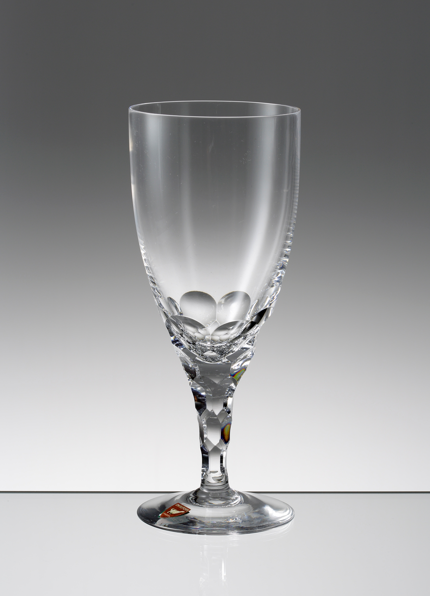 Design: Ingeborg Lundin.
Ölglas. Tulpanformad kupa med fasettslipad nedre del. Konande ben med fasettslipade fjäll.