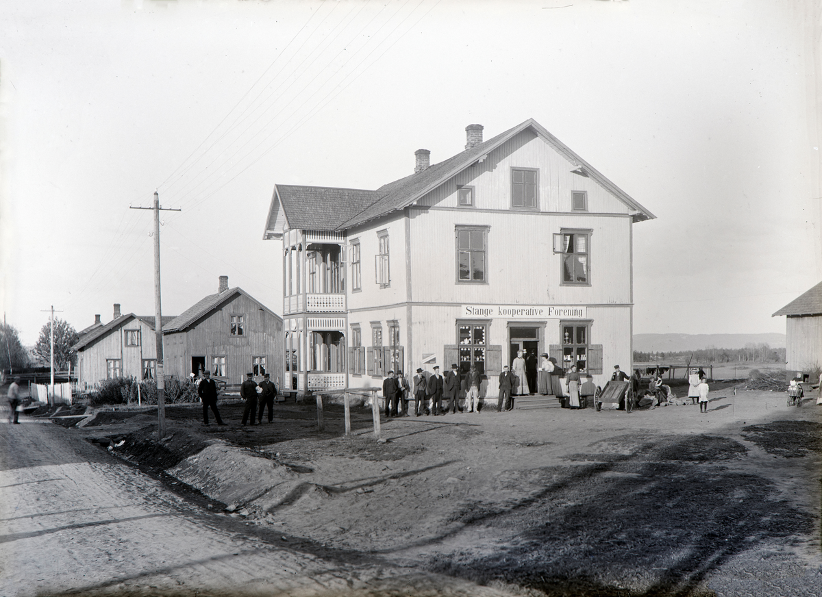 Stange sentrum, Stangebyen, Kristian Fjelds gate, Vaterland, Skramstadgården, Stange Kooperative Forening som etablerte seg her i 1908, landhandel, butikk, stor gruppe mennsker foran butikken.