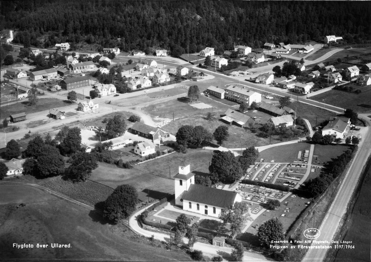 Flygbild över Ullared. Ullareds kyrka och kyrkogård. Bybebyggelse med enfamiljshus, hyreshus och trädgårdar.