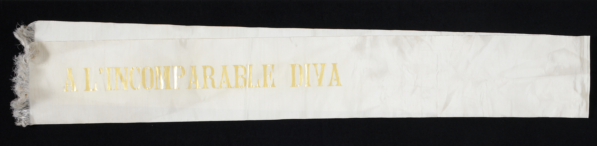 Vitt hyllningsband i siden med förgylld skrift; "Un admirateur inconnu. A l'incomparable diva".

Inskrivet i huvudkatalog 1933.