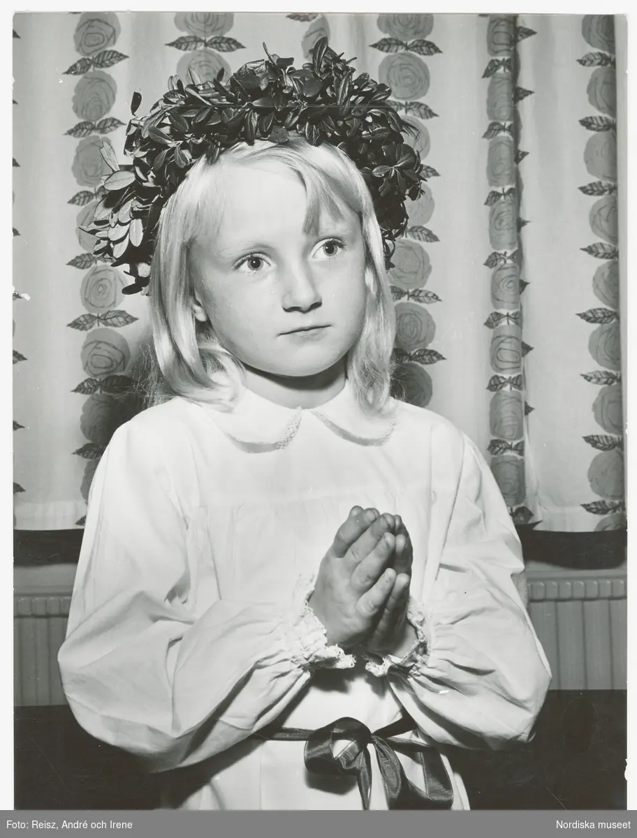 Lucia. Porträtt av en flicka klädd i Luciaklänning och med en krans på huvudet
