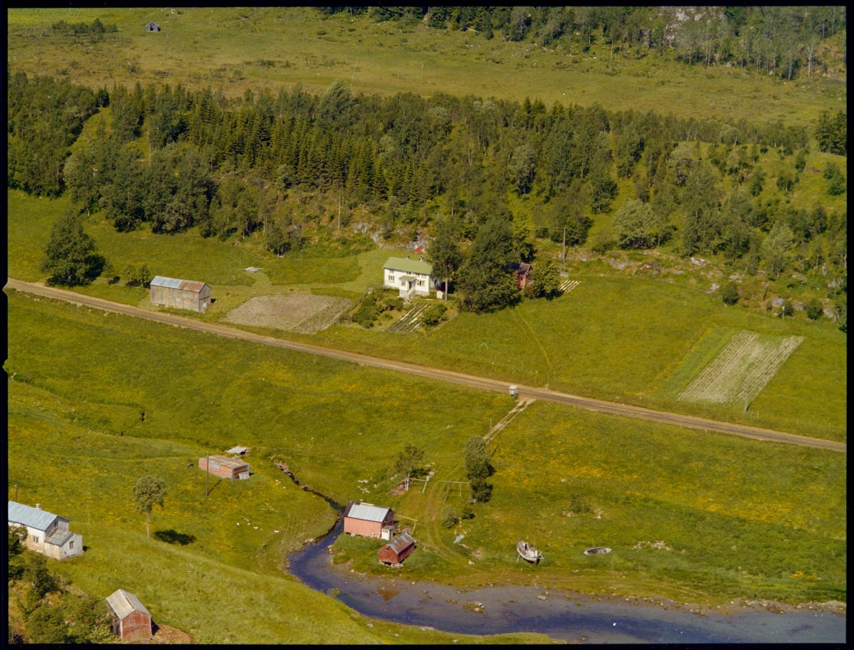 Leirfjord, Breiland. Flyfoto over deler av Breiland. På gården midt på bildet bodde Johan Grønnvik. Huset nederst i venstre hjørnet kalles "huset i Osneset", området kalles også "Breilandsosen". Det store naustet ved elveosen tilhører Johan Grønnvik.
