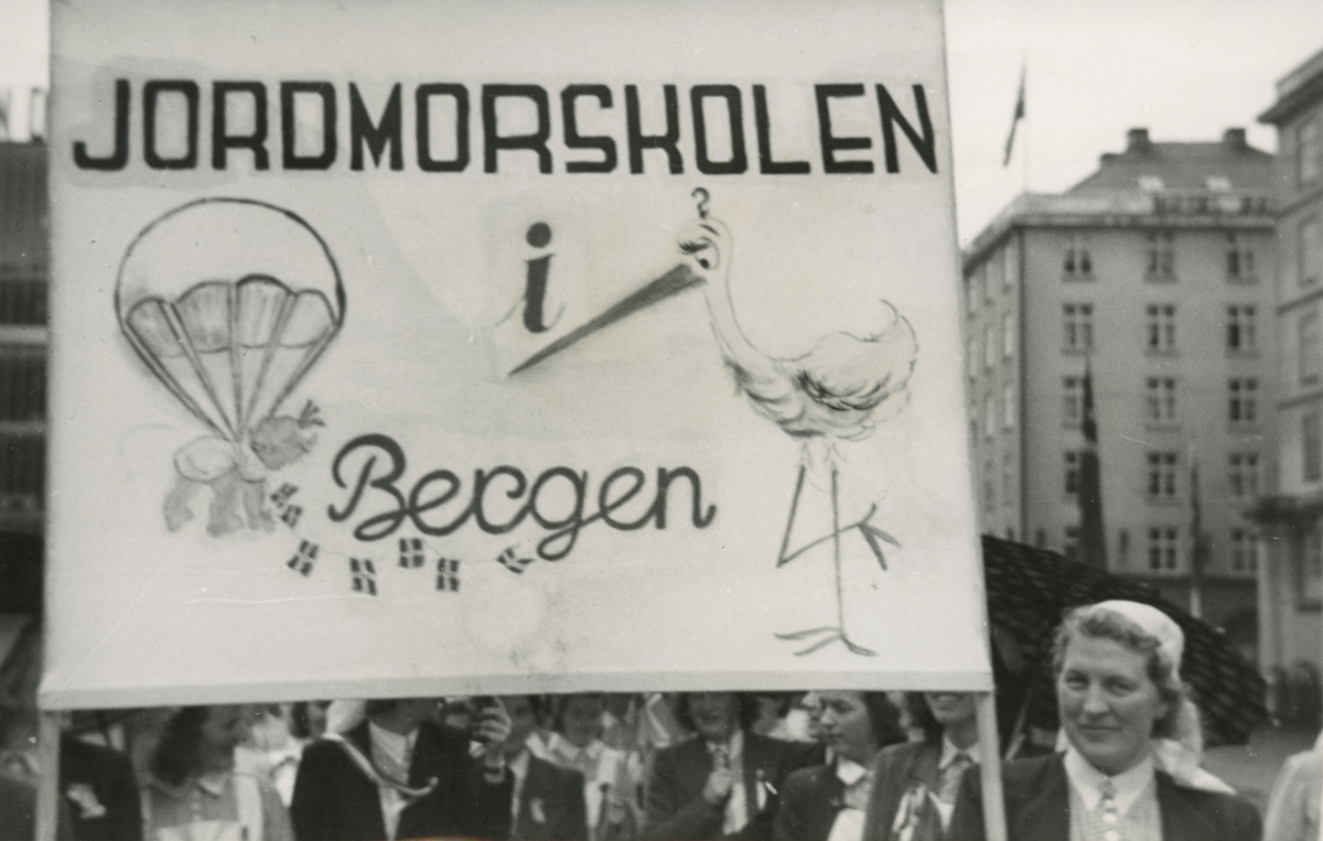 Et opptog ved 17. mai feiring i Bergen. Jormorstudenter bærer fanen til Jordmorskolen.