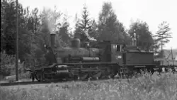 Damplokomotiv type 18c nr. 241 med grusvogn ved vannstendere