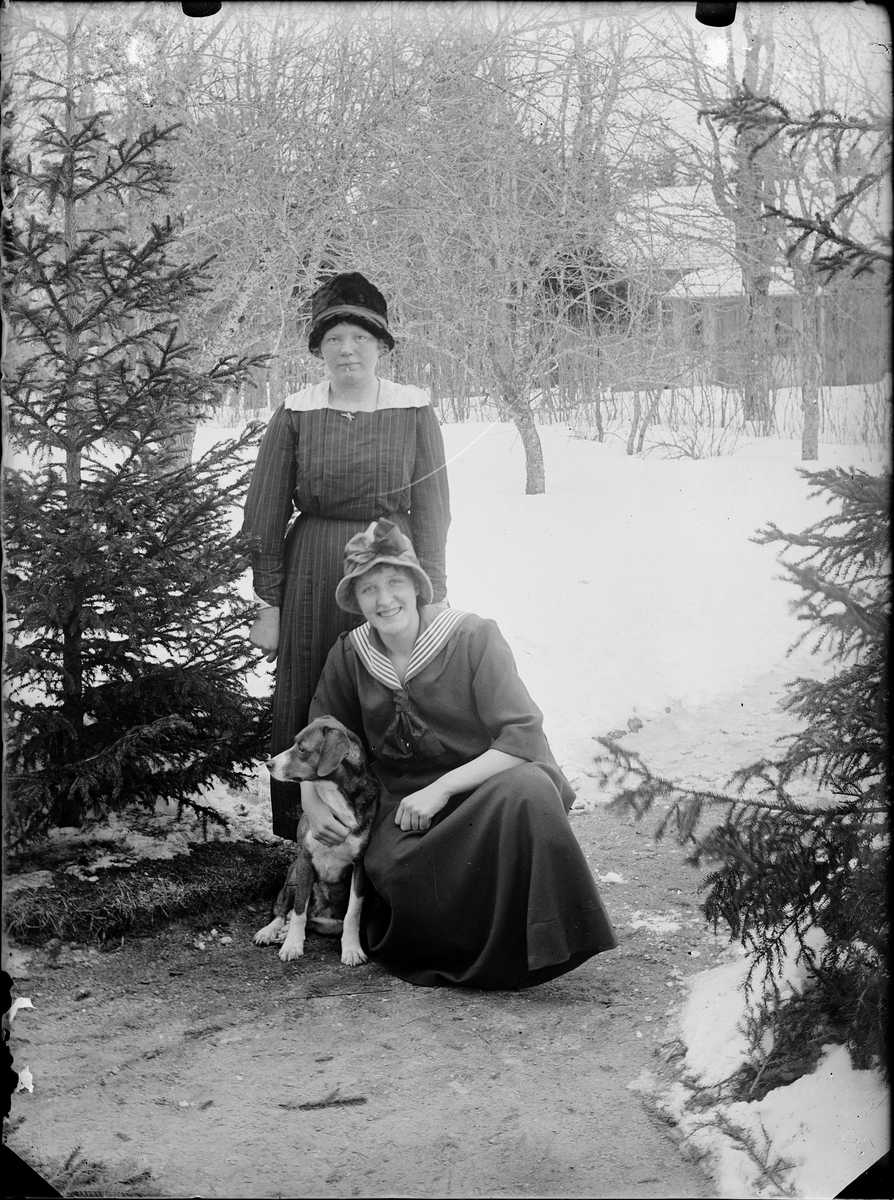Två kvinnor och en hund står i trädgård, Alunda, Uppland