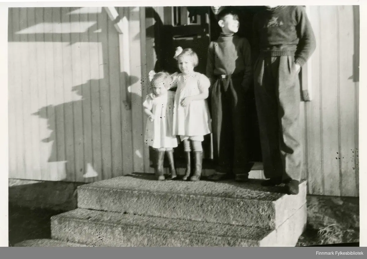 Søster Berit hadde kjole sydd av foret i en gammel dressjakke. Eli hadde kjole sydd av et gammelt dynetrekk. To brødre, våren 1945, Trøgstad der familien Alexandersen  bodde under evakueringen. 