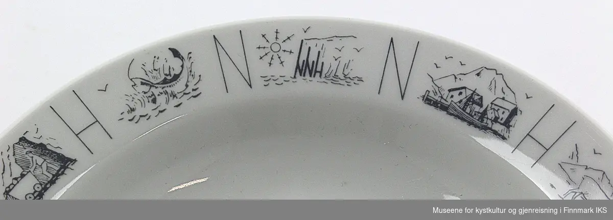 Dyptallerken fra Nordnorsk Hotelldrift med Nordkappmotiv. Det står NNH rundt tallerkenen med motiv mellom hver bokstav.
Motiv av rein, båter, gruvedrift og Nordkapp,  