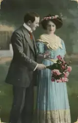 Postkort med motiv av ei kvinne og mann med rosebukett.