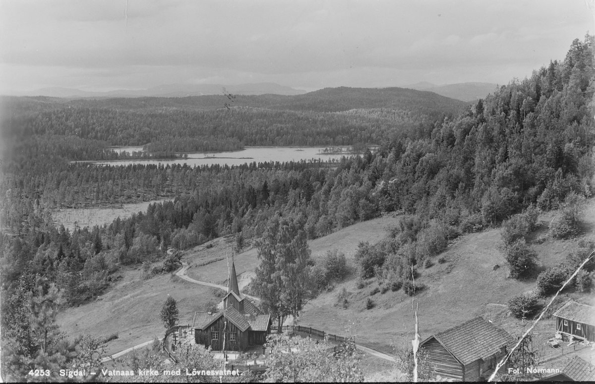 Vatnås kirke og gård, med Løvnesvannet i bakgrunnen. Postkortmotiv, ca. 1938.