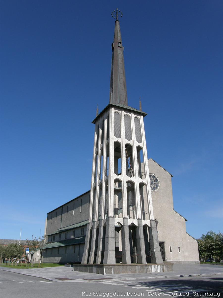 Bodø domkirke er tegnet av arkitektene Blakstad og Munthe-Kaas etter en arkitektkonkurranse i 1947. Kirken er bygd i jernbetong og har en monumental basilikalignende hovedform med frittstående klokketårn, og ble innviet i 1956. Arkitektene beskriver bygningen som en søyleløs basilika. Ved siden av koret ligger menighetssalen og en kontorfløy. Over hovedinngangen er en skulptur av den den seirende Kristus laget av Kristoffer Leirdal og på sydfasaden en skulpturen av Petter Dass.

Inventar og utsmykning er preget av umalt oregon-pine og lyse overflater på murverk. Det opprinnelige interiøret er godt bevart, men fargene på noen av veggflatene ble justert ved oppussing i 1994. Den har et tønnehvelvet skip og et smalere kor med tønnehvelvet himling som en forlengelse av himlingen over midtskipet. På en tverrbjelke i et korgitter av betong mellom kor og skip står en kalvariegruppe laget av Kristoffer Leirdal og Tone Thiis Schjetne. Store glassmalerier i fondveggen over alteret forestiller Himmelfarten og er tegnet av Aage Storstein og utført av Borgar Hauglid. I skipet henger ti knyttede ryer med kristne symboler laget av Sigrun Berg.


Kilde: NIKUs kirkearkiv