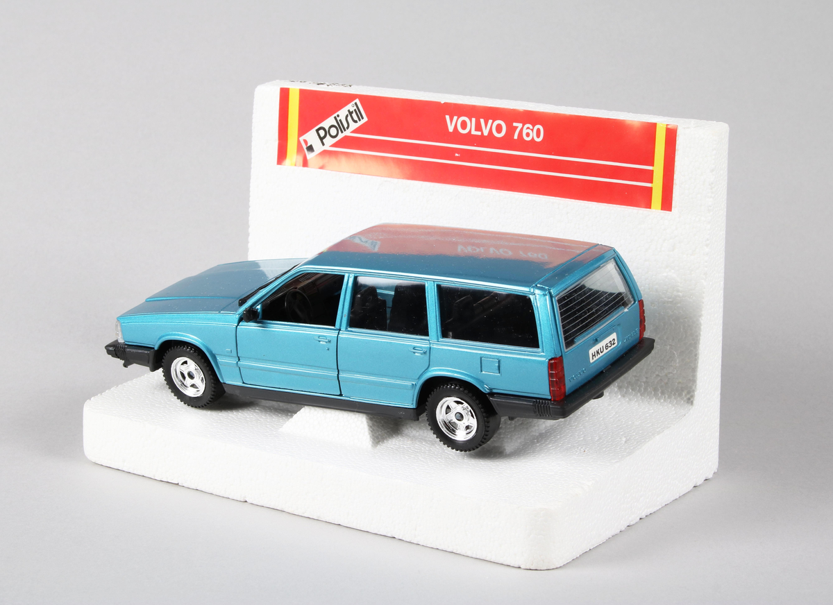 Leksak i metall och plast. Personbil "Volvo 760", årsmodell 1983. I färgen "turkosfärgad metallic med silverfälgar". Underredet svart. Framdörrar och bagagelucka går att öppna. Står på vit frigolitplatta märkt: "Polistil VOLVO 760". Förvaras i originalkartong.