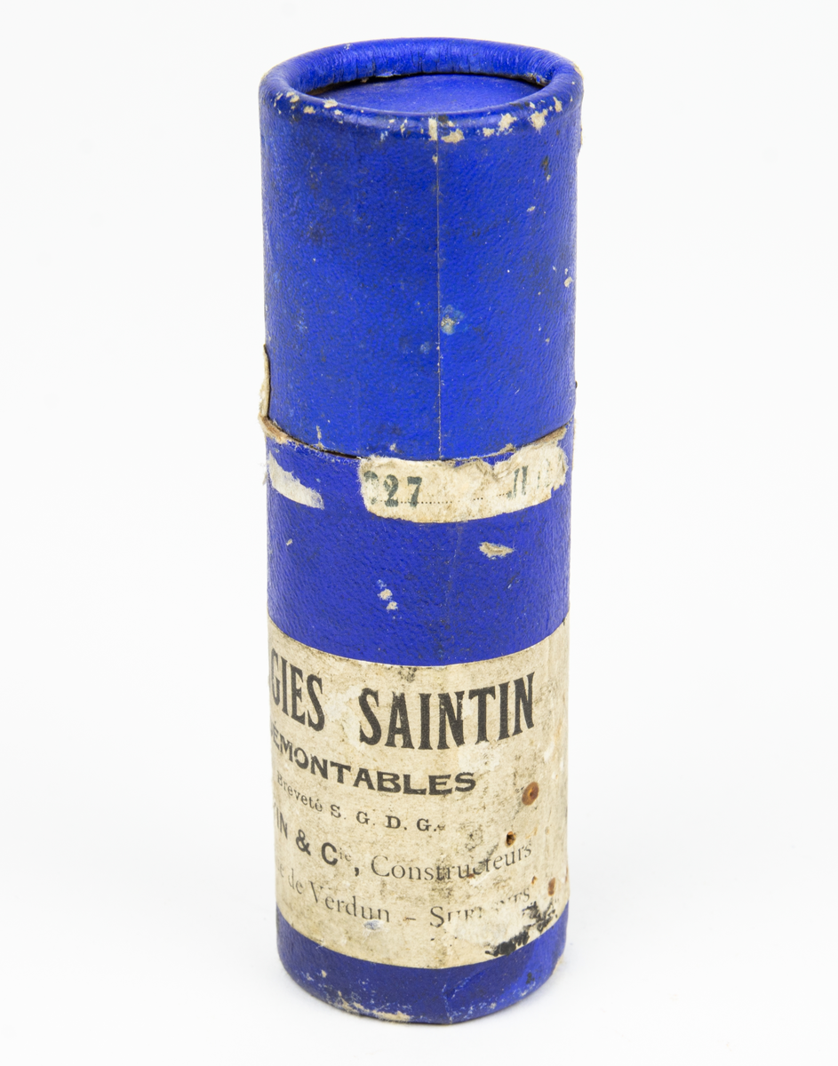 Tändstift, av fabriketet Saintin. Förvaras i originalförpackning i form av ett blått papprör med etikett med bland annat texten Bougies Saintin och dateringen 1927. I förpackningen följer en dokument. (Tändstift för motorer med hög kompression och hög hastighet.)