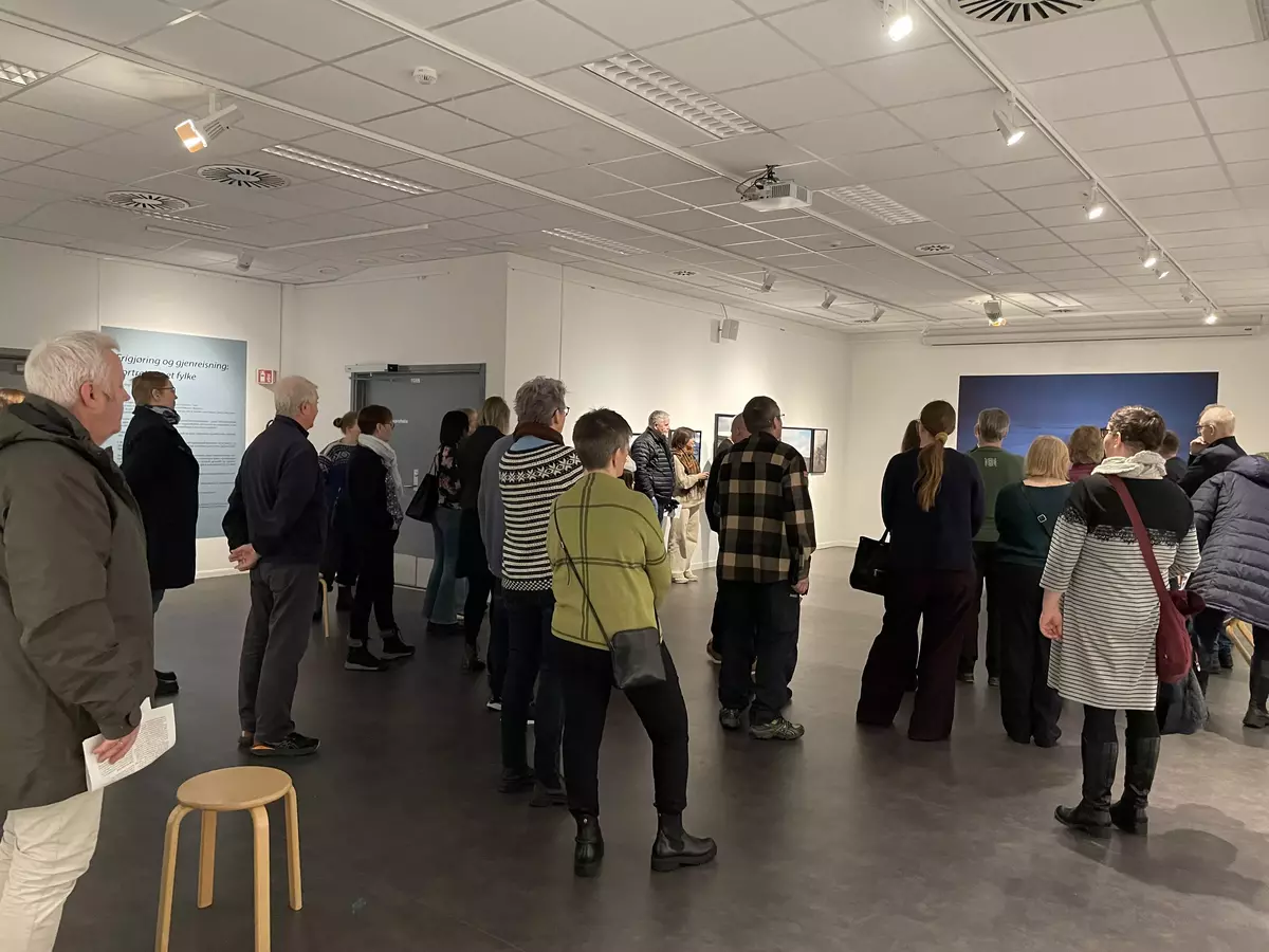 Folk under åpning av utstillingen "Frigjøring og gjenreisning: portrett av et fylke" av Ingerid Jordal.