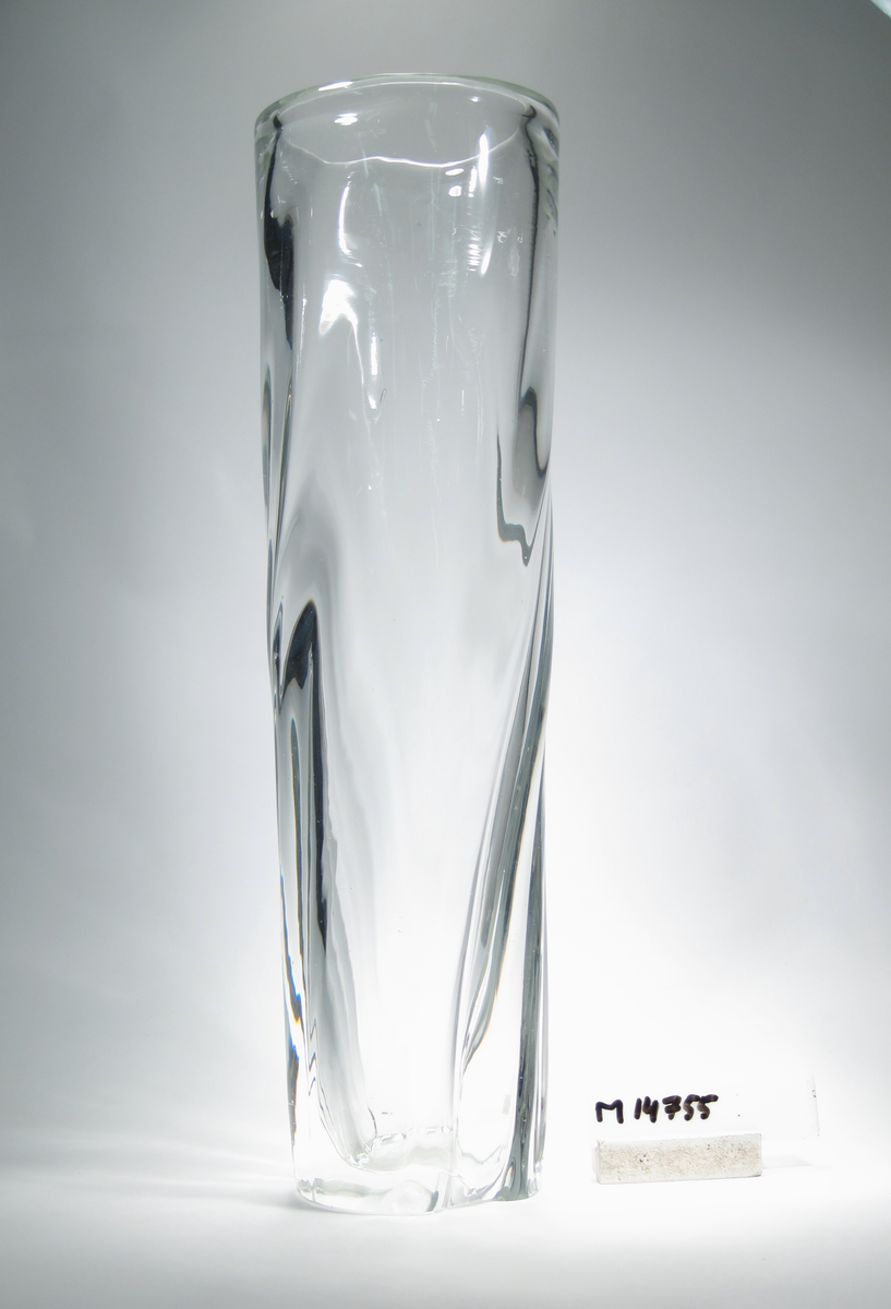 "Uppståndelsen" formgiven av Gunnel Nyman. Cylinderformad, svagt avsmalnande neråt, med en lätt spiralvriden godronnering. Slipad botten.