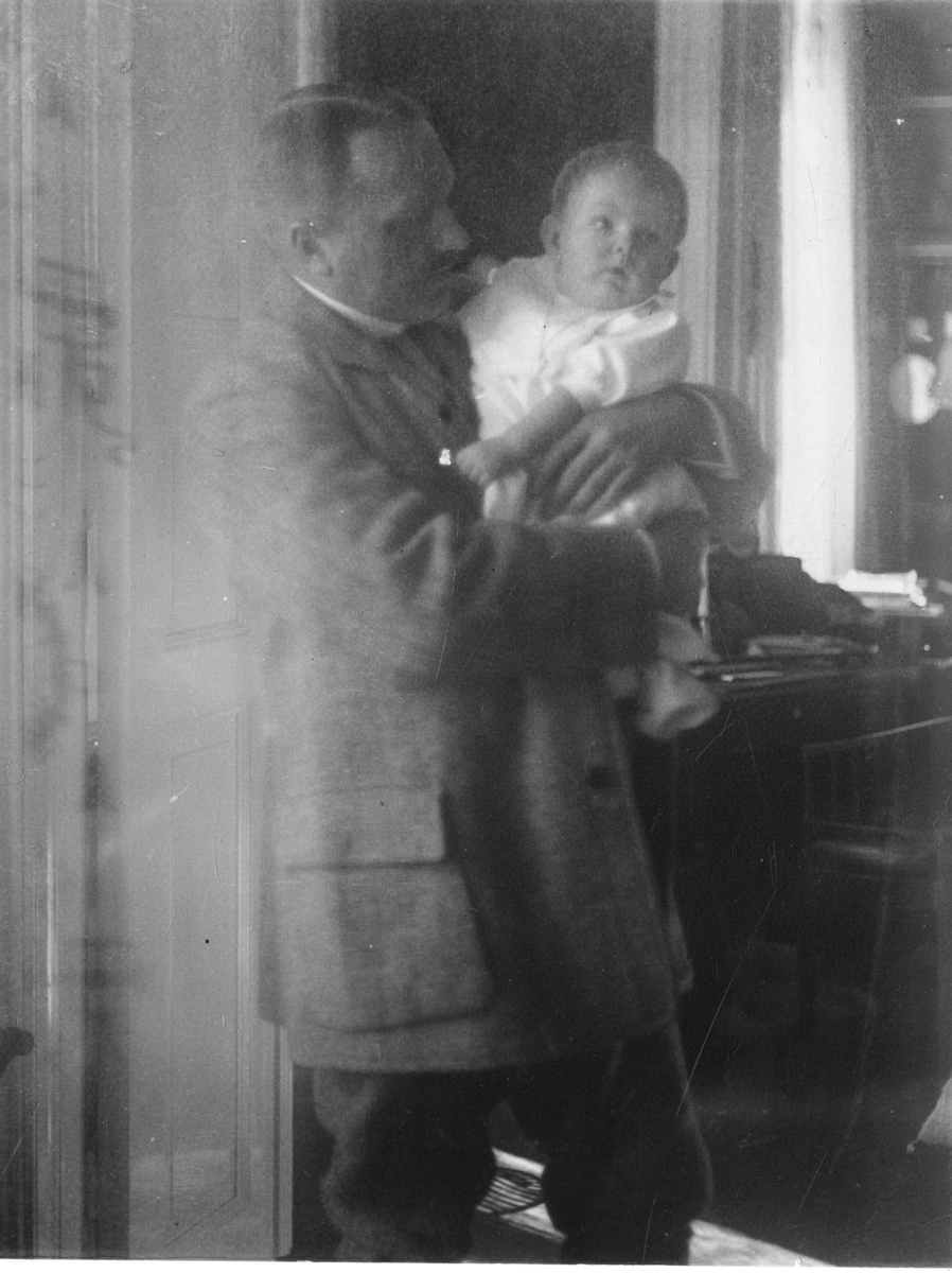 Foto av mann med barn i ermene. Antagelig er barnet Nils Frederik Aall og mannen hans far, Cato Aall