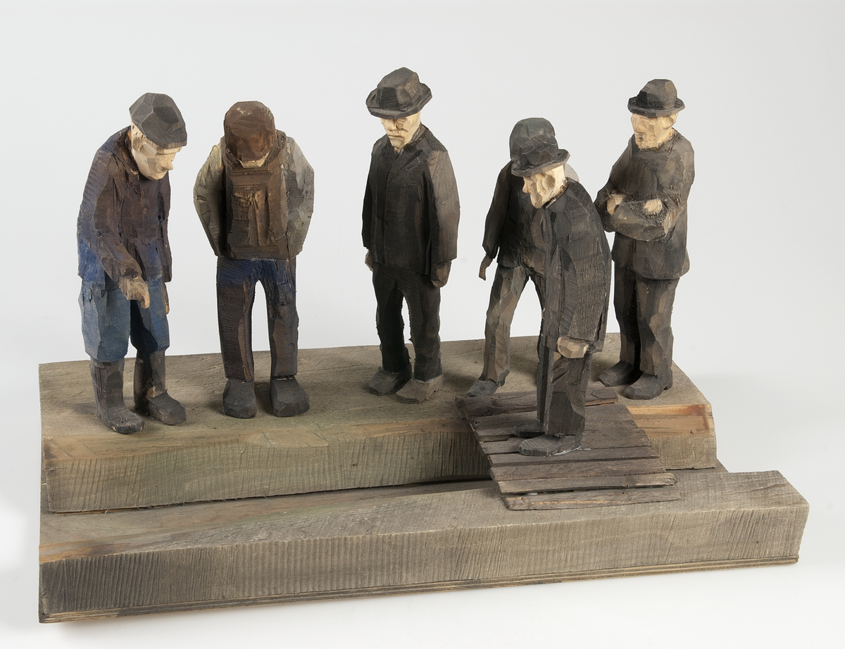 Skulptur av trä. "Dikessyn", tillverkad av Hans Lustig.

Skulpturscenen föreställer sex män betraktande ett dike, över diket går en enkel träbro, på vilken den ene av männen står. Hela gruppen är placerad på en träplatta.