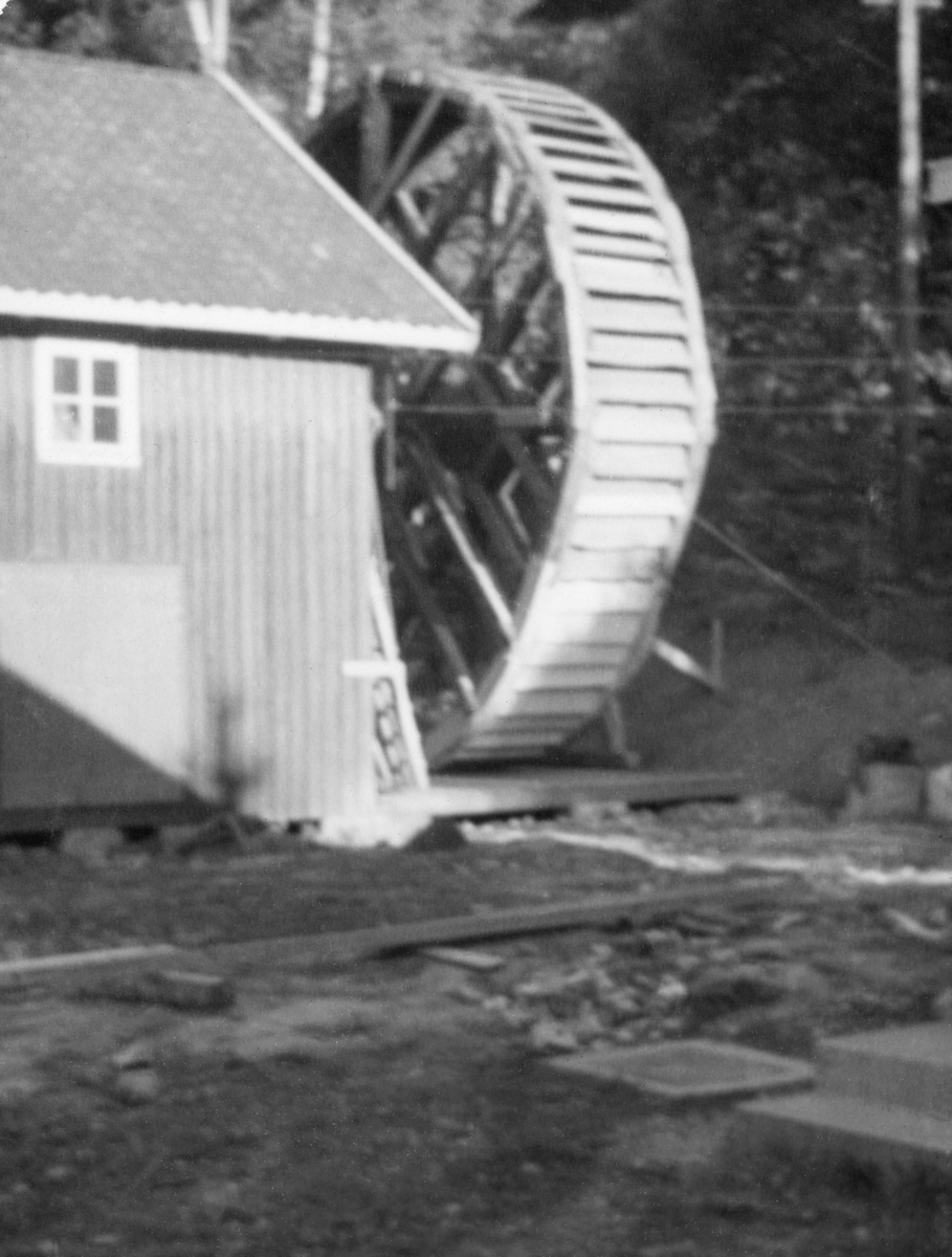 Stort overfallshjul, montert ved en bygning ved Eidet i Tune i Østfold, der Glomma fellesfløtingsforening hadde et lenseanlegg. Hjulet skal opprinnelig ha stått ved Sanne og Solli bruk i Ågårdselva, ikke langt fra Eidet. Bildet skal være tatt i 1937.
