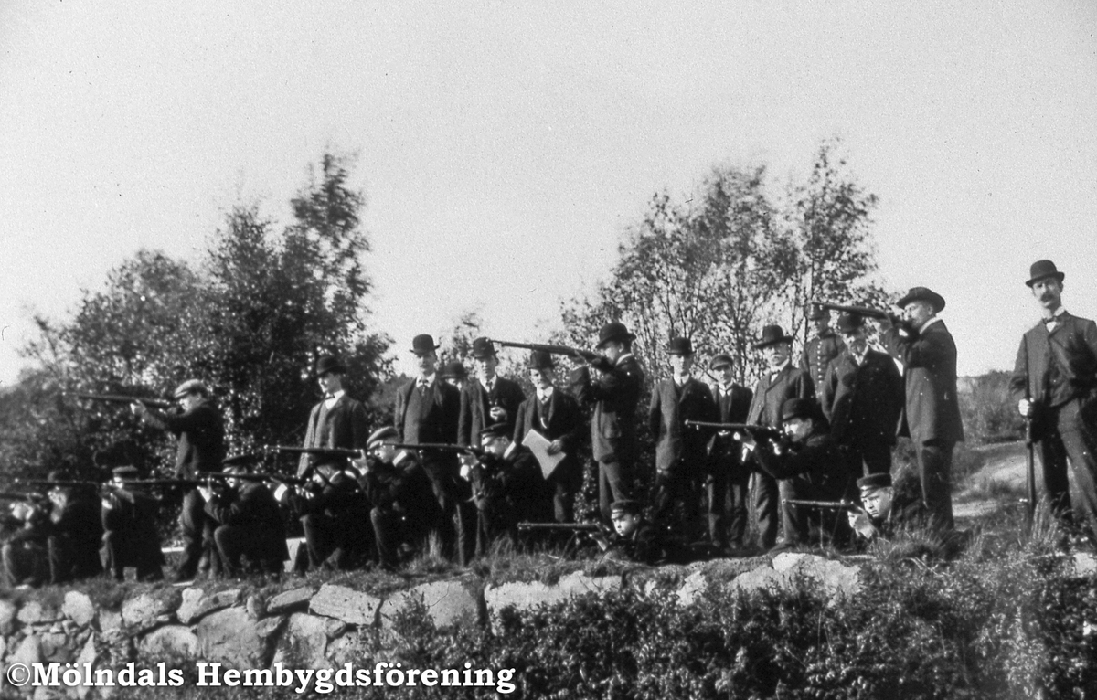 En samling herrar skjuter med gevär vid skjutvallen på Kikås i östra Mölndal. Okänt årtal. AF 13:9.