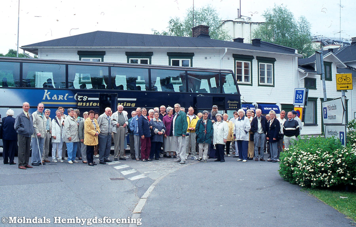 Vassända Naglums Hembygdsförening besöker Kvarnbyn i Mölndal och blir guidade där den 16 maj 2001. Bakom bussen skymtas huset Götaforsliden 1-5.