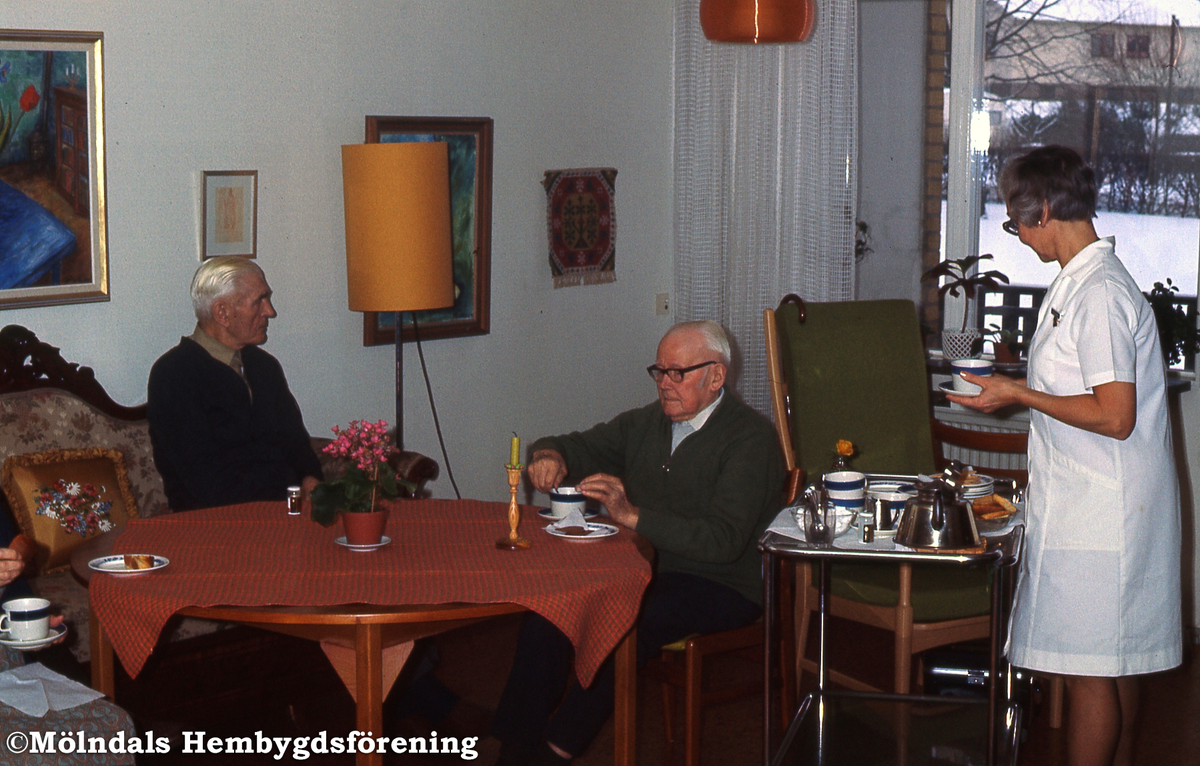 Märta Holmberg serverar fika till två manliga pensionärer på Lackarebäckshemmet i Mölndal, år 1973. K 2:28.