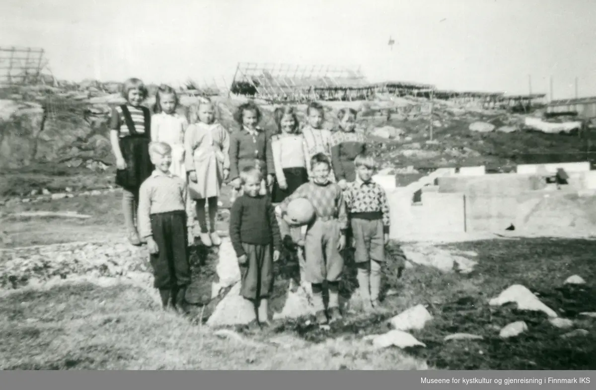 Gruppebilde av flere barn. En av guttene har en ball under armen. Kanskje tatt i Kamøyvær, muligens 1955.