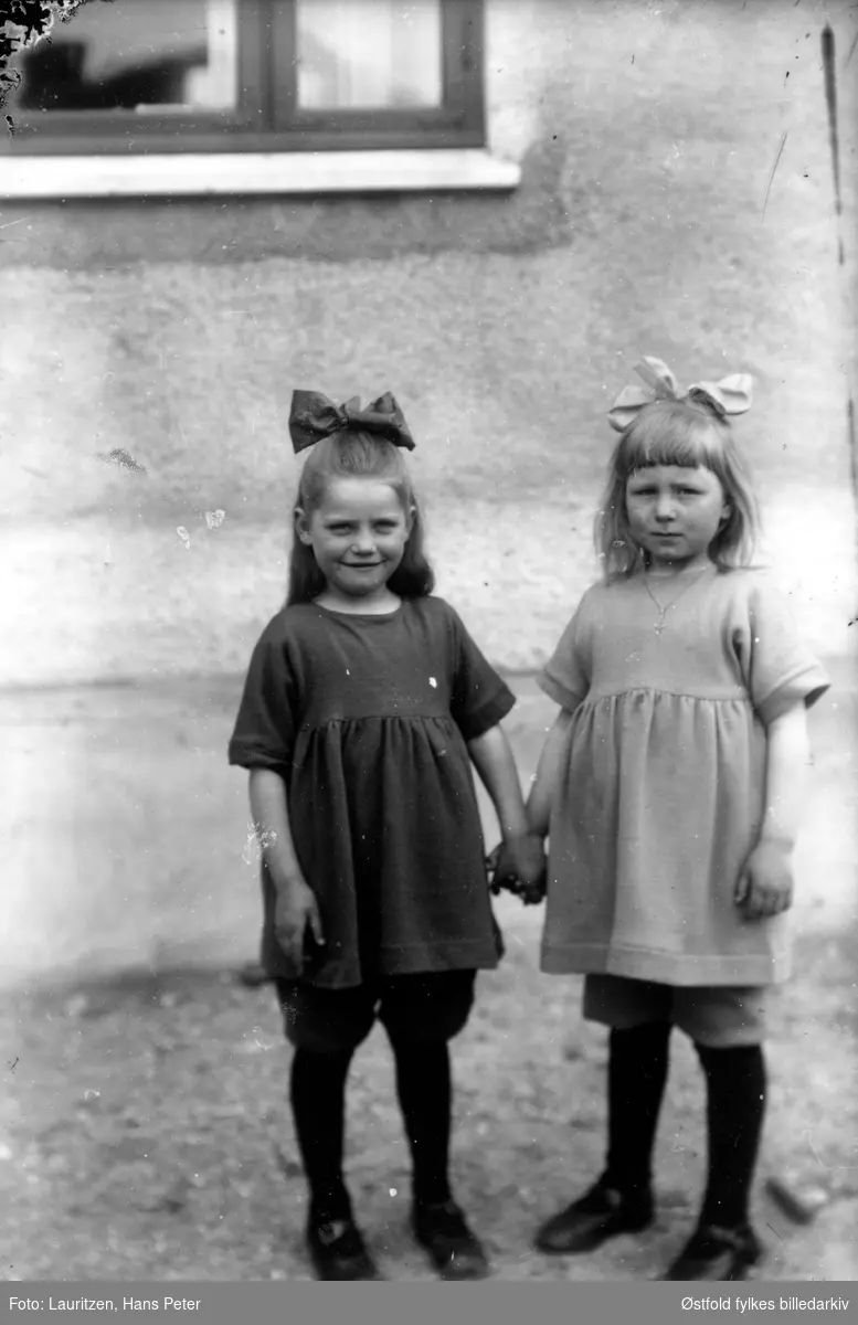 Venninne Vera Mostrøm og Dagar Lauritzen hånd i hånd.
Begge med sløyfe i håret. Ca. 1922-23. Dagar Lauritzen er fotografens datter.